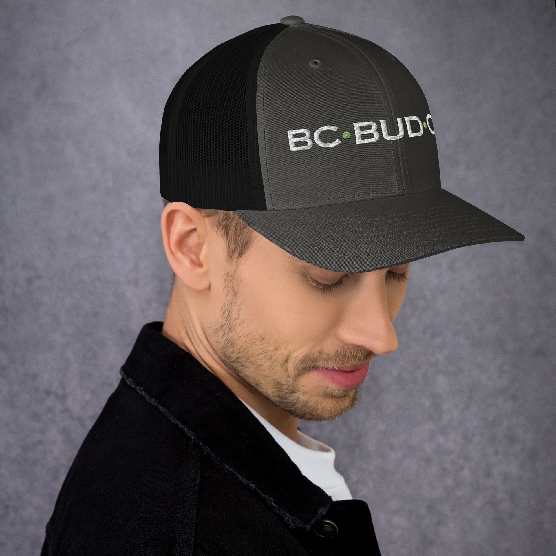 A man wearing a hat that says bc bud on it