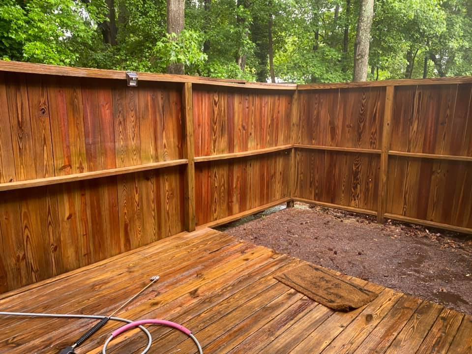A wooden deck with a wooden fence in the background.