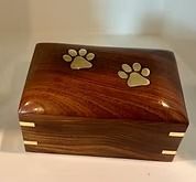 Wooden pet urn with paw print inlays.