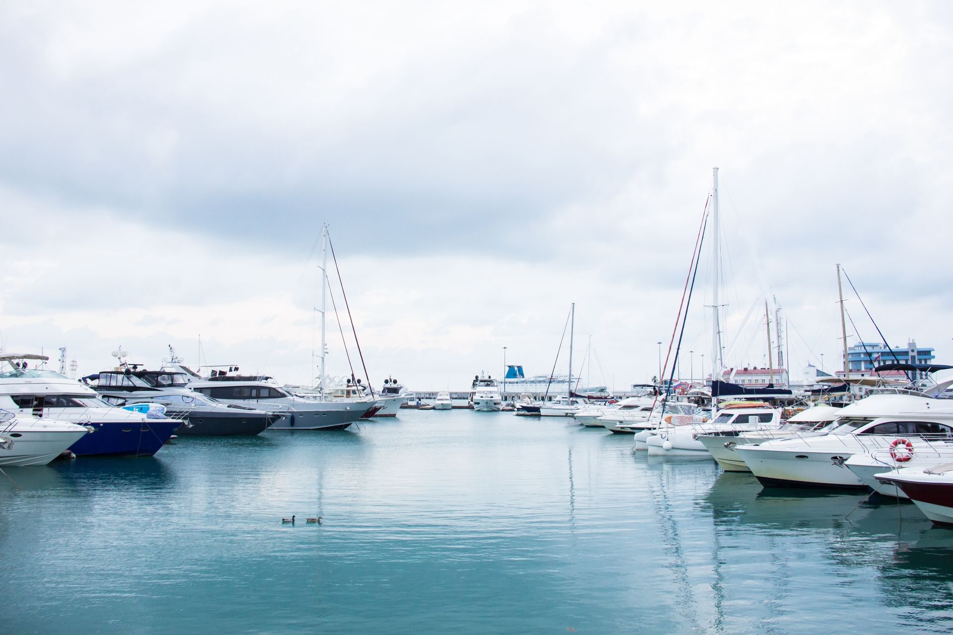 Boats docked in a harbor under a cloudy sky.