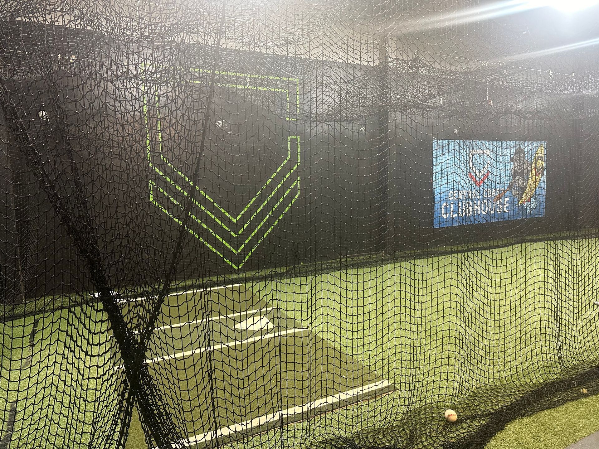 A baseball cage with a sign that says cleats on it