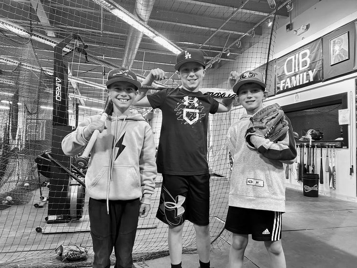 Three young boys are posing for a picture at the clubhouse 831.