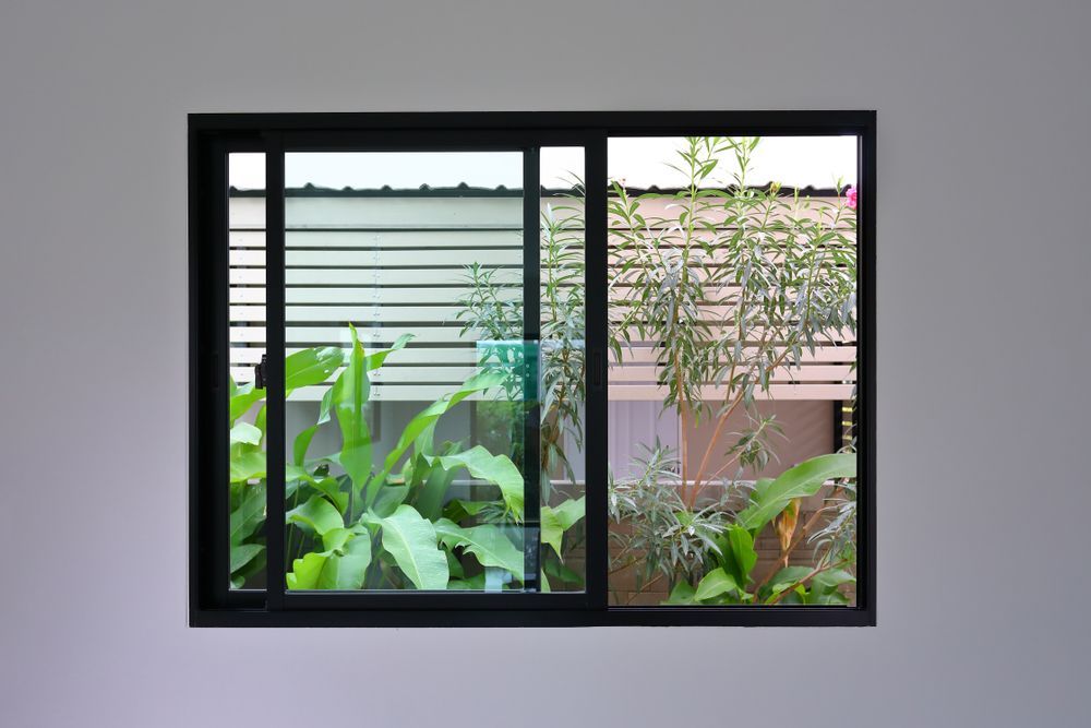 A window with a sliding glass door looking out to a garden  — Southside Glass & Aluminium In Bentley Park, QLD