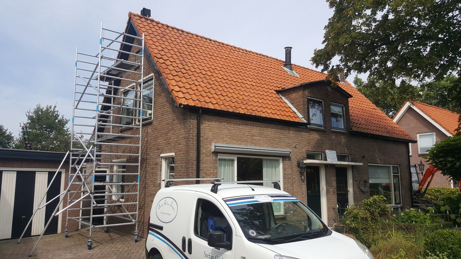 Bakstenen huis met steiger, mijn vorige bedrijfswagen ervoor geparkeerd; schilder werkzaamheden zijn in volle gang.