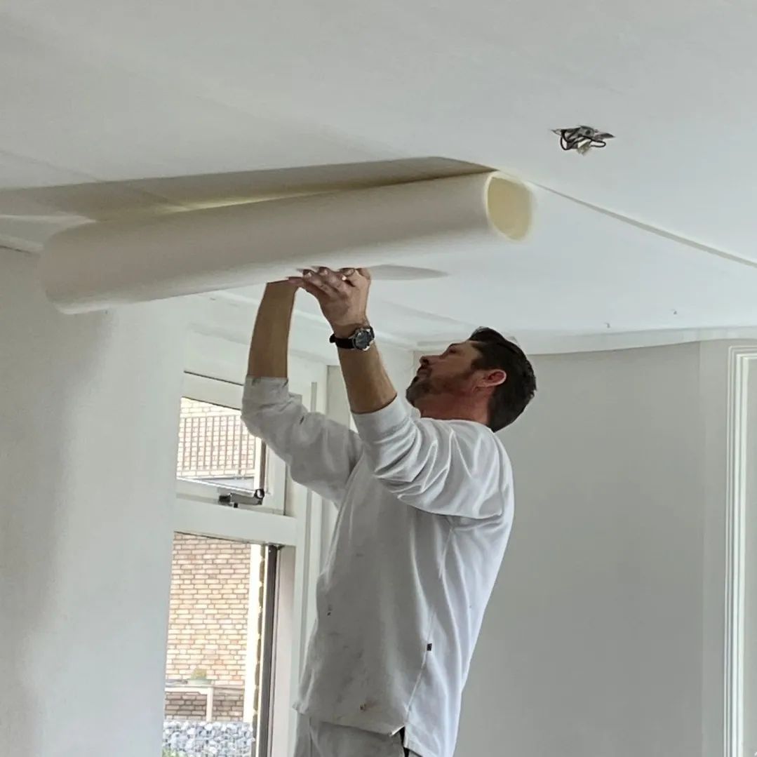 Stefan plakt renovlies behang op gipsplaat plafond.