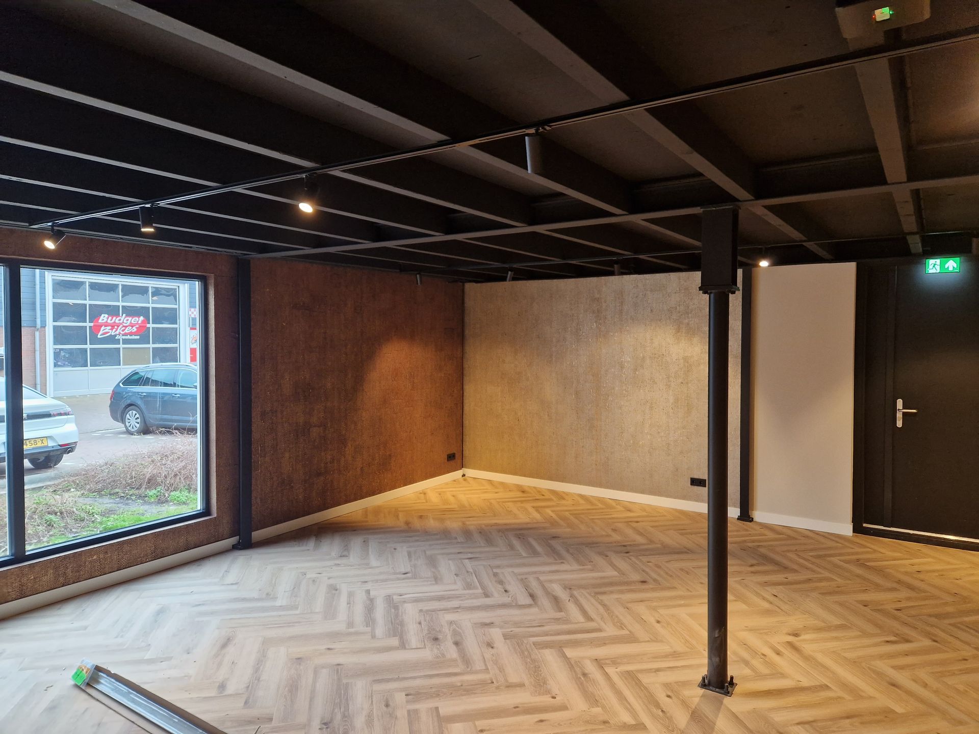 Resultaat van het spuitwerk van een zwart plafon en behangwerk.