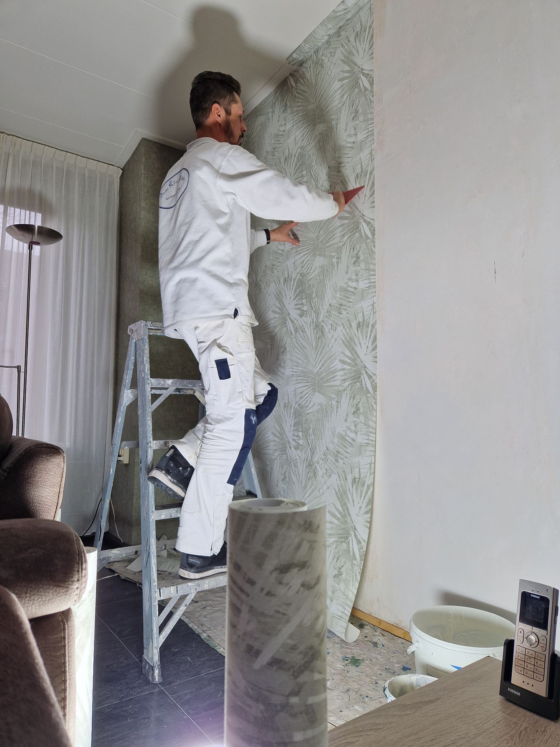 Stefan Godrie die binnenshuis behangt.