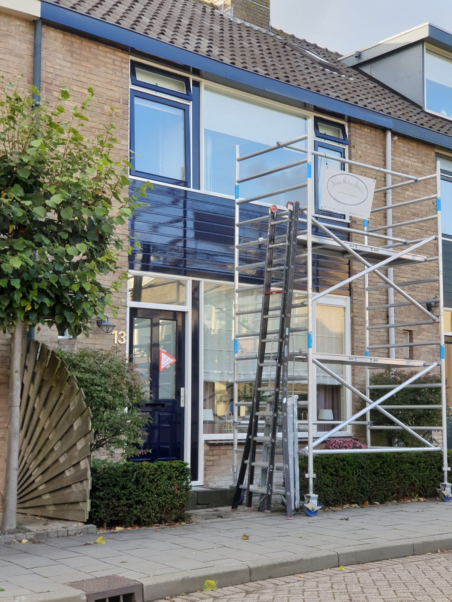 Buitenkant schilderen van het huis met steiger.