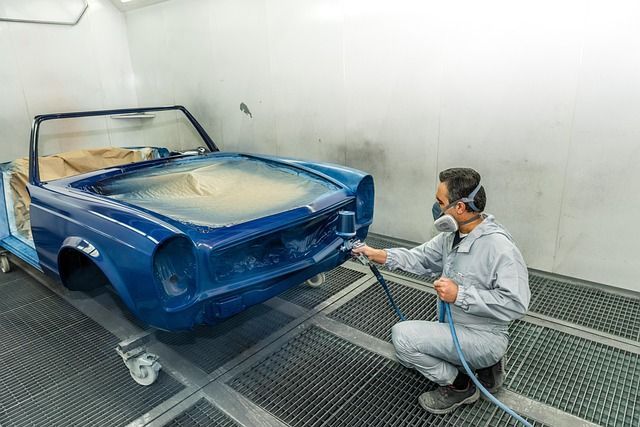 auto aan het spuiten in een spuitcabine