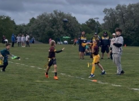 Flag football game being played, non-contact, boy throws ball to open receiver.