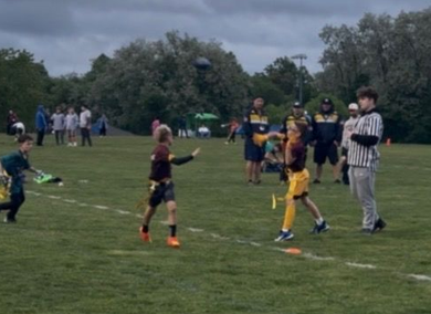 Flag football game being played, non-contact, boy throws ball to open receiver.