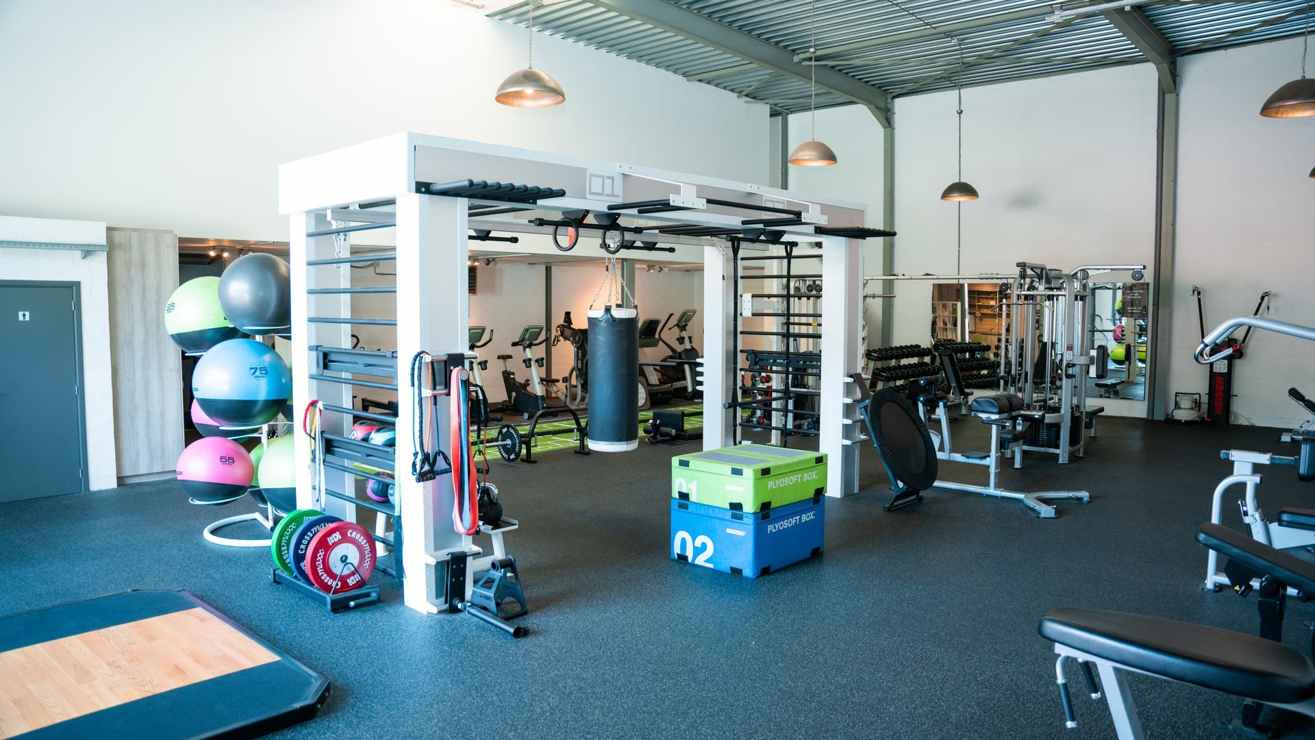 Een grote sportschool vol met fitnessapparatuur.