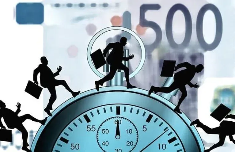 Silhouetted figures running on a stopwatch, currency in the background; concept of time and money.