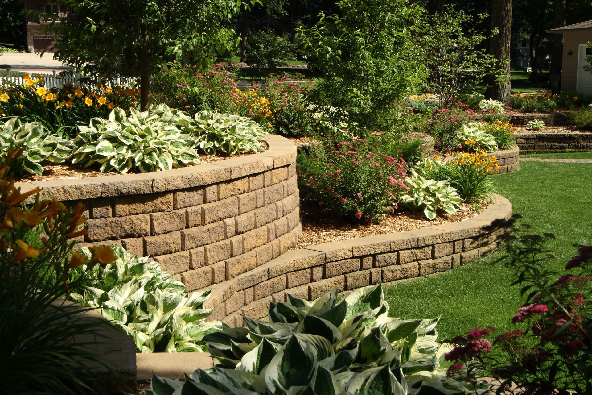 A garden with a brick wall and lots of plants