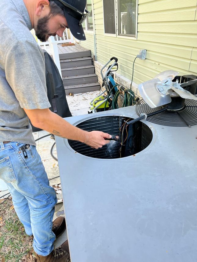 A white air conditioner is mounted on the side of a building.