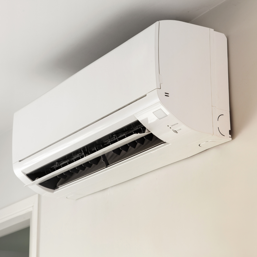 A white air conditioner is mounted on a wall