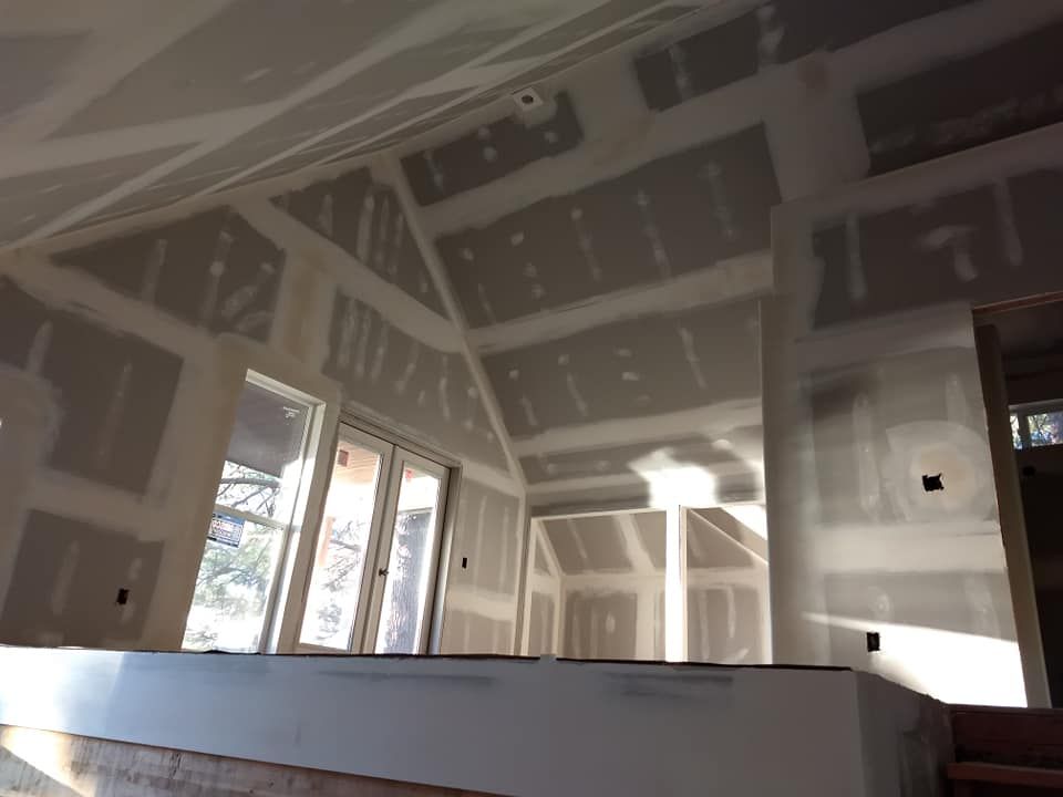 A room with a lot of windows and drywall on the walls