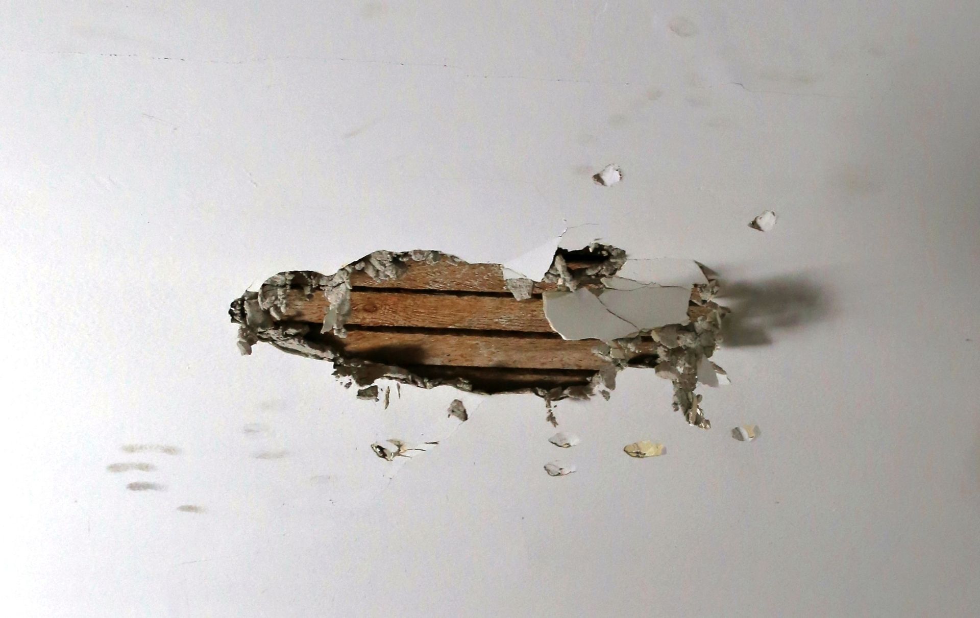 A hole in a wall with a piece of wood in it