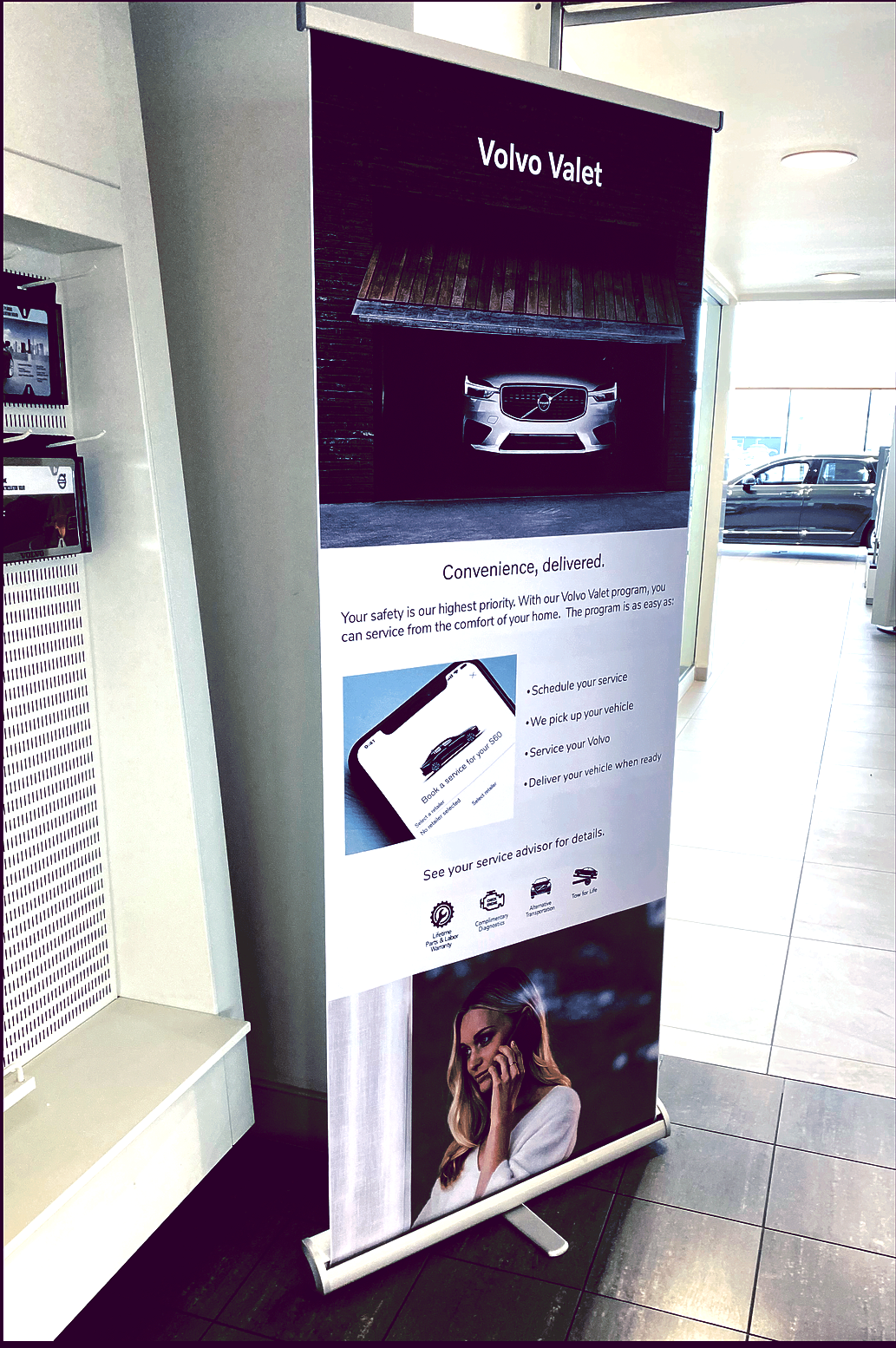 A volvo roll up banner is displayed in a showroom