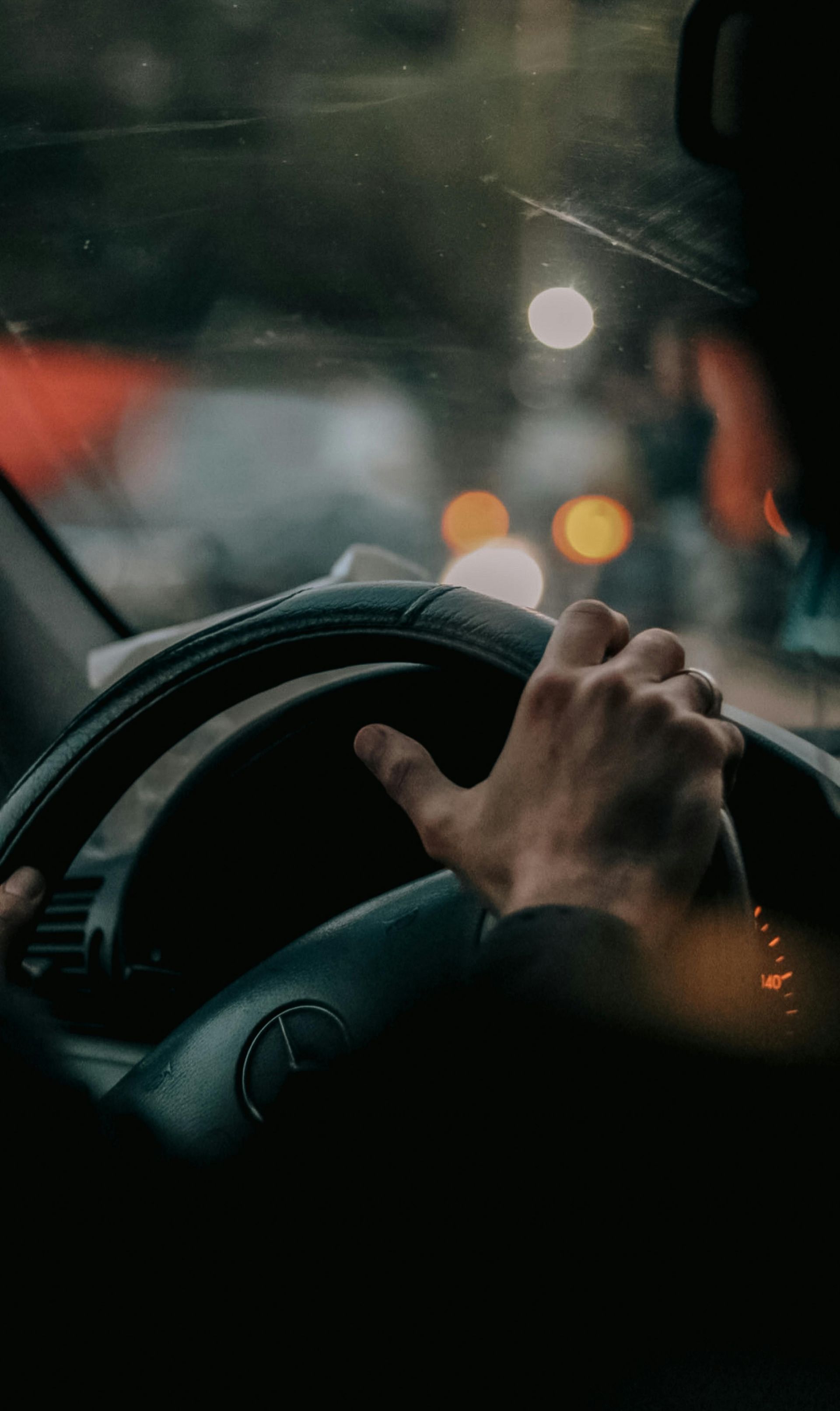 Chauffeur driving a luxury vehicle through city traffic, representing limo service professionalism.