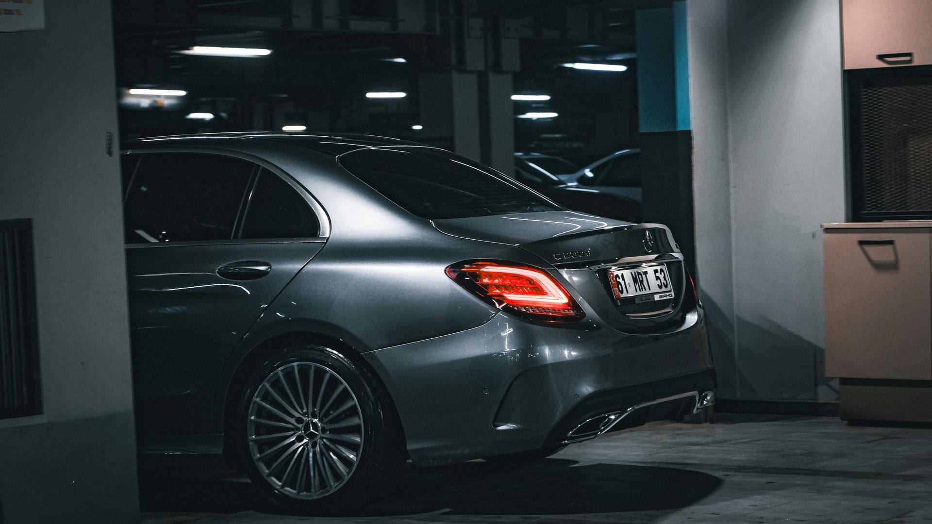 Luxury black SUV parked outside an upscale downtown hotel entrance at night in a chauffeur service s
