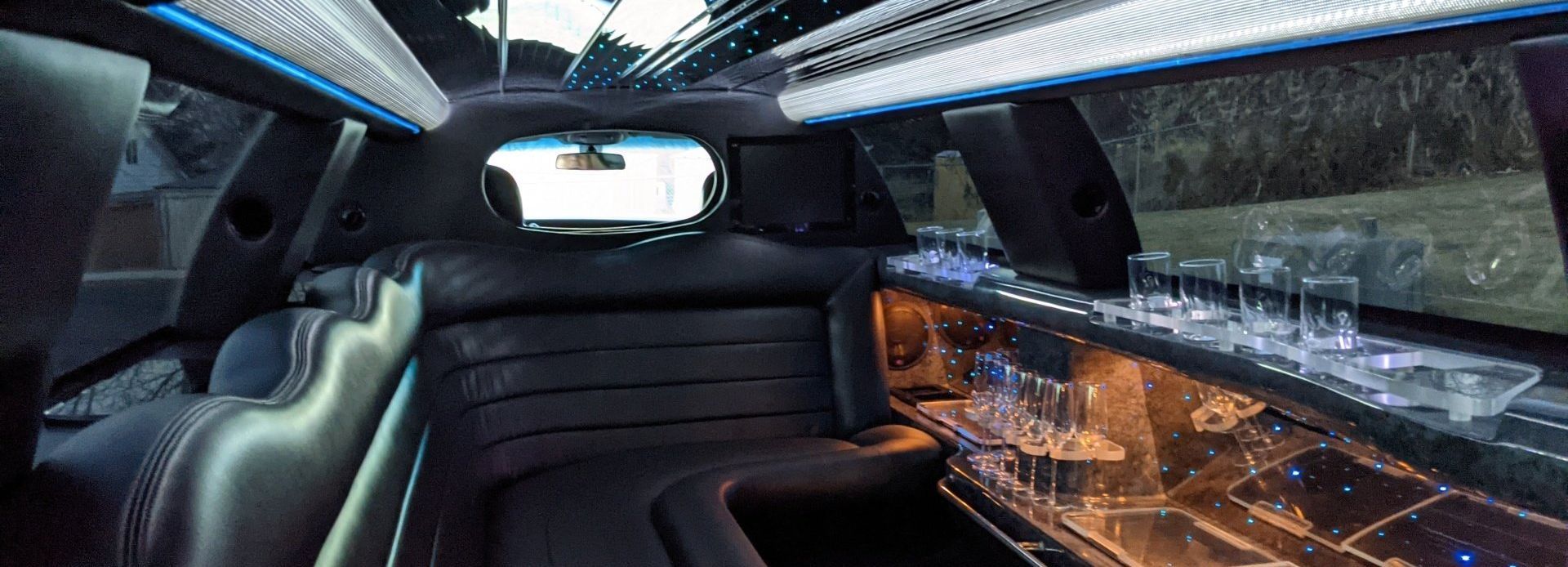 the inside of a limousine with a bar and glasses on it .