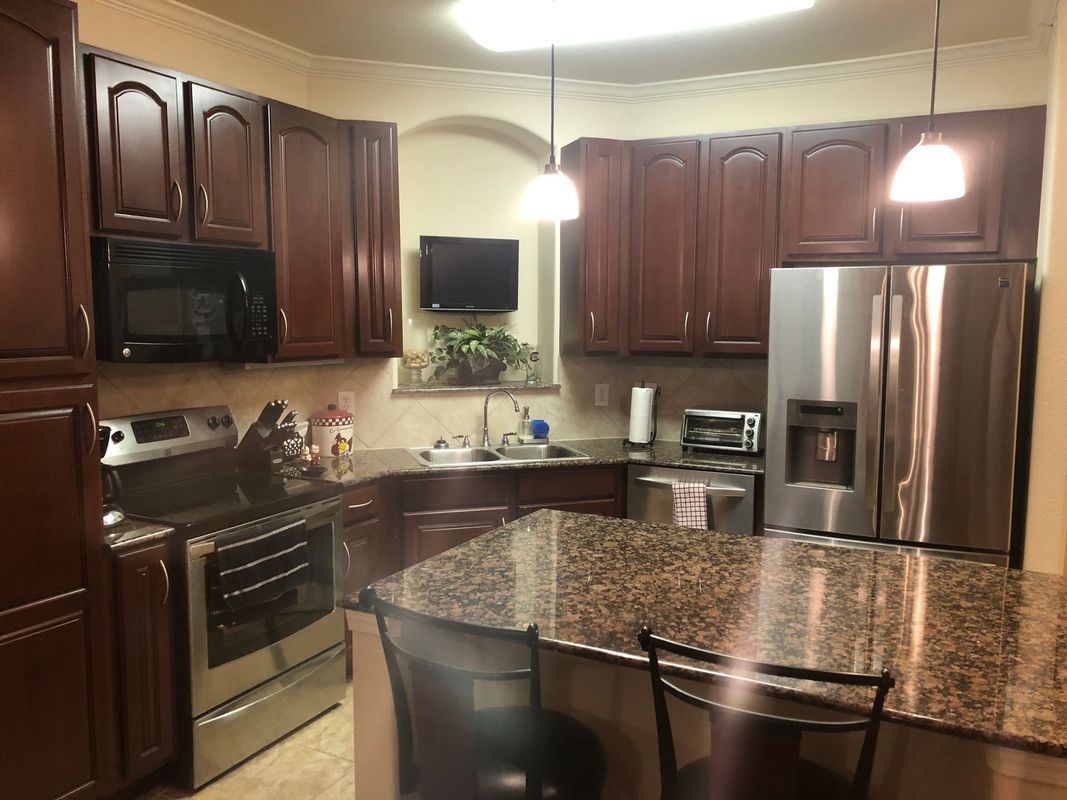 Kitchen with brown cabinets, granite countertops, and stainless steel appliances.