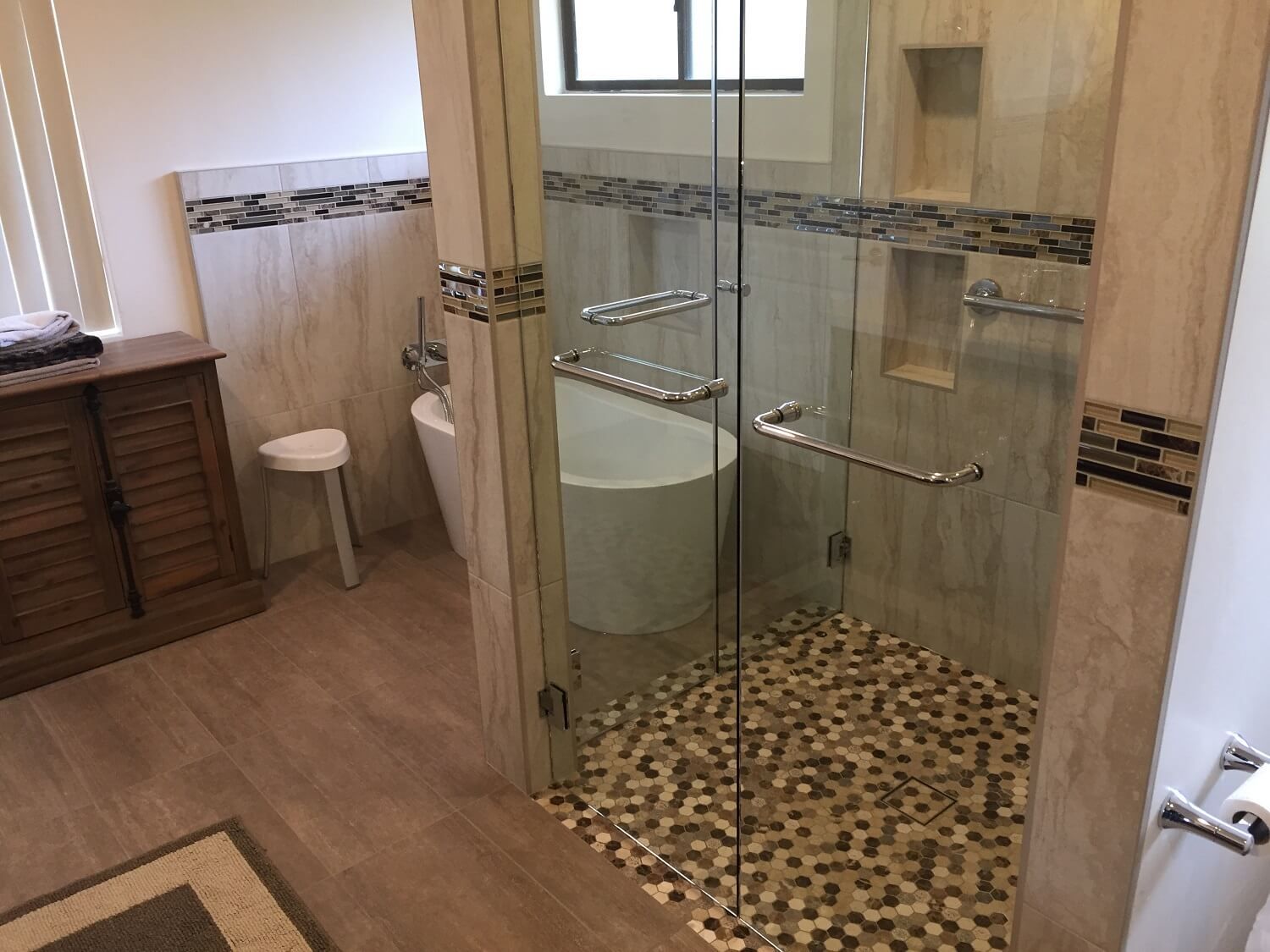 A bathroom with a tub and a walk in shower.