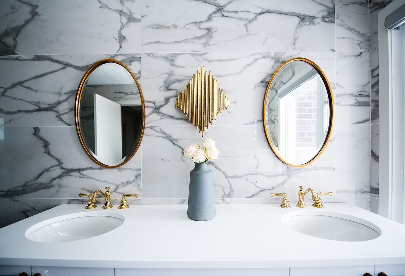 A bathroom with two sinks and two mirrors on the wall.