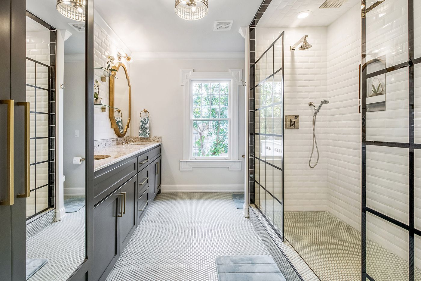 A bathroom with two sinks and a walk in shower.