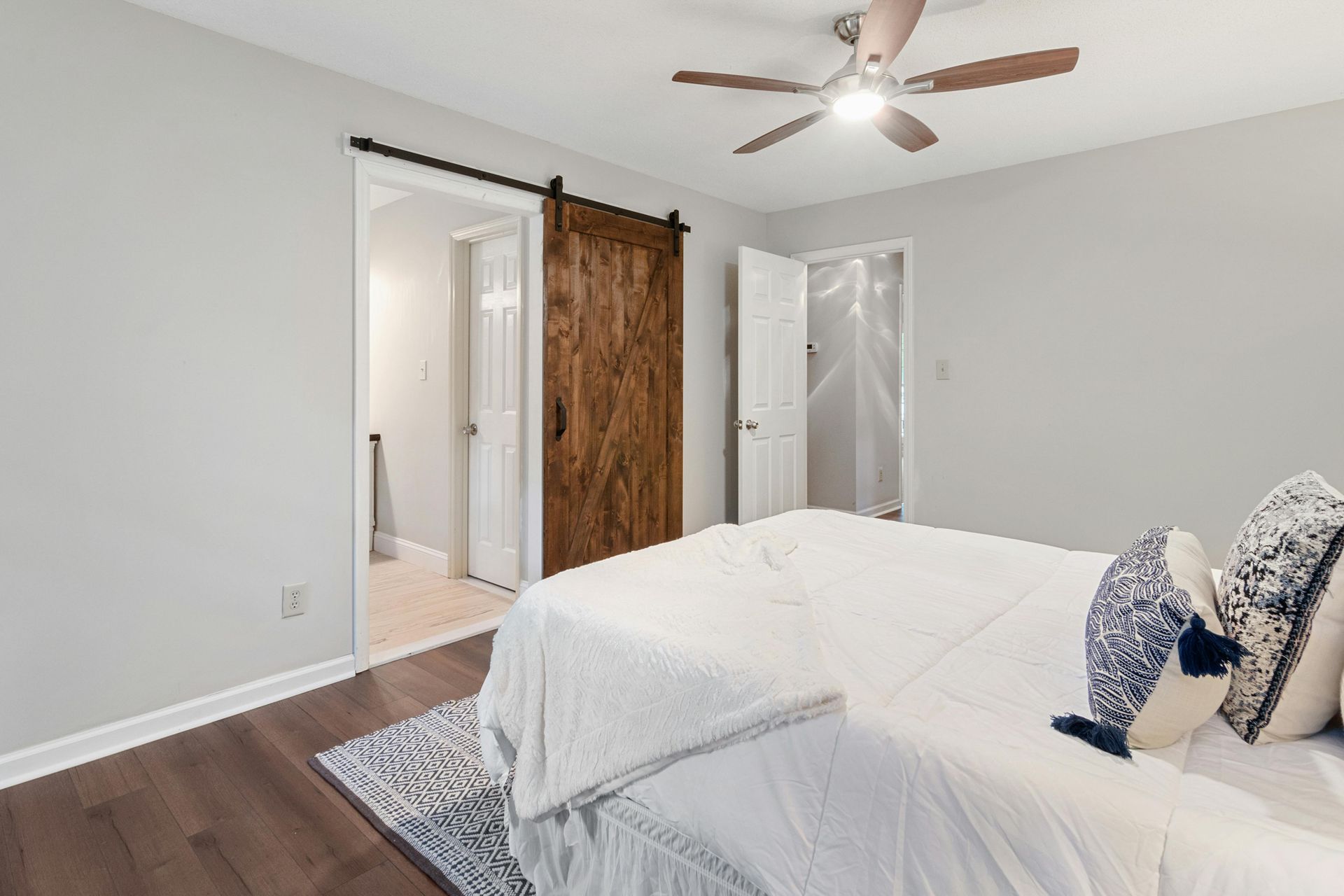 Newly painted bedroom, with white bed and gray walls.