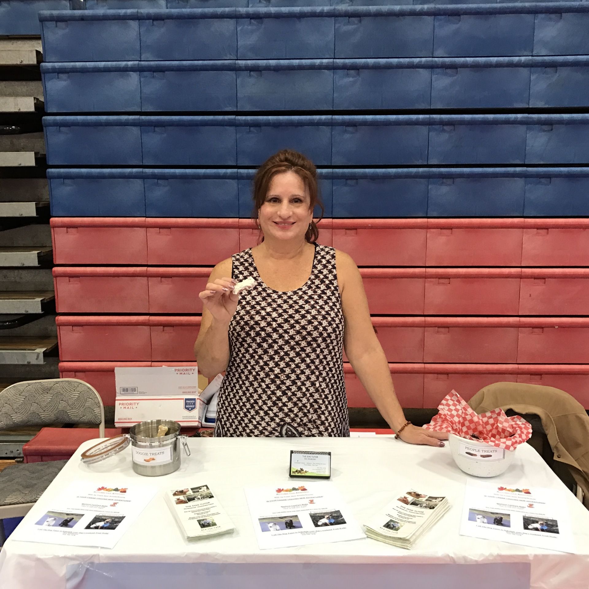 A woman is standing at a table holding a cookie.