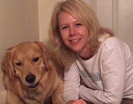 A woman is sitting next to a dog on a couch.