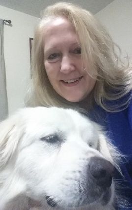 A woman is taking a selfie with a white dog.