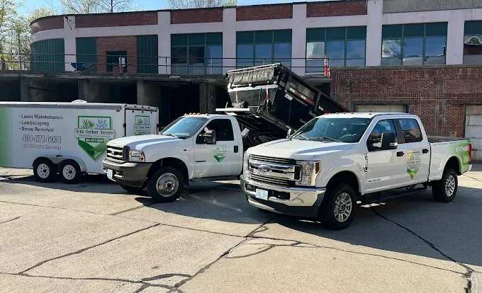 Two trucks and a trailer are parked in front of a building.