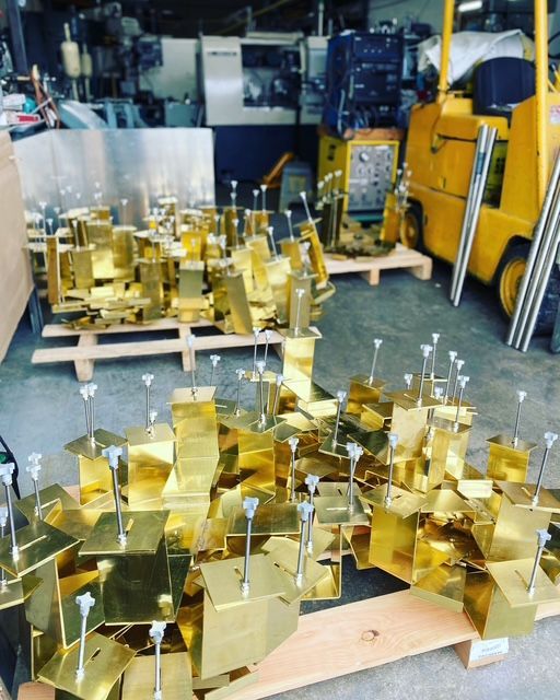 A bunch of gold pieces are sitting on a wooden pallet