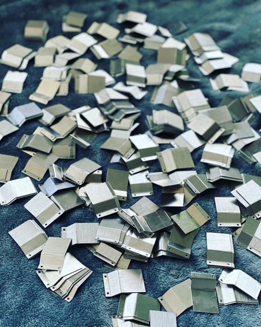 A pile of silver squares on a blue surface