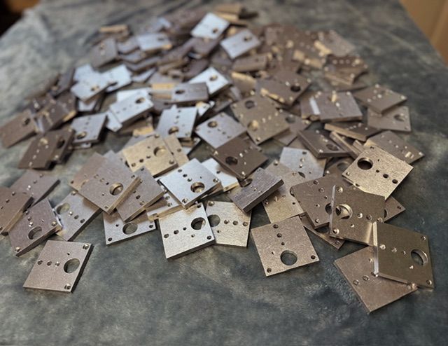 A pile of metal pieces with holes in them