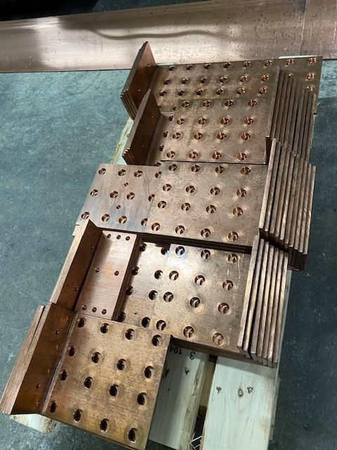 A bunch of metal pieces are stacked on top of each other on a wooden pallet.