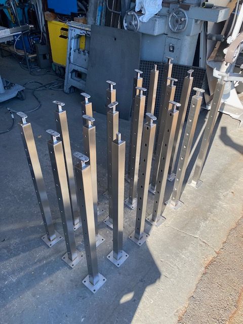 A bunch of stainless steel poles are sitting on the ground