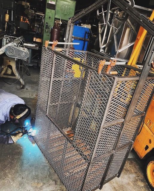 A man is welding a metal cage in a garage