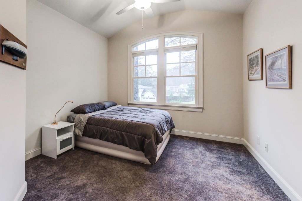 A bedroom with a bed and a ceiling fan
