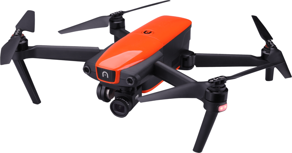 An orange and black drone is flying in the air on a white background.