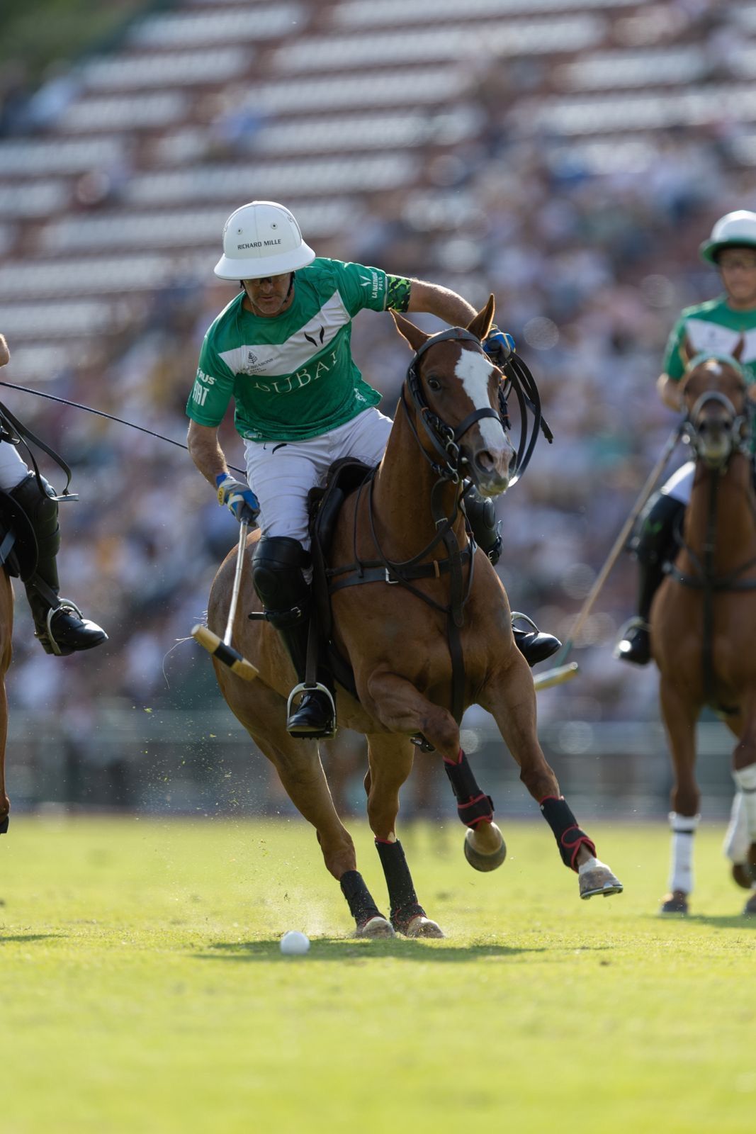 a man is riding a horse while playing polo on a field .