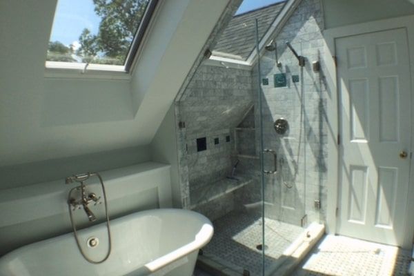 Bathroom with skylight, glass shower, and claw-foot tub.