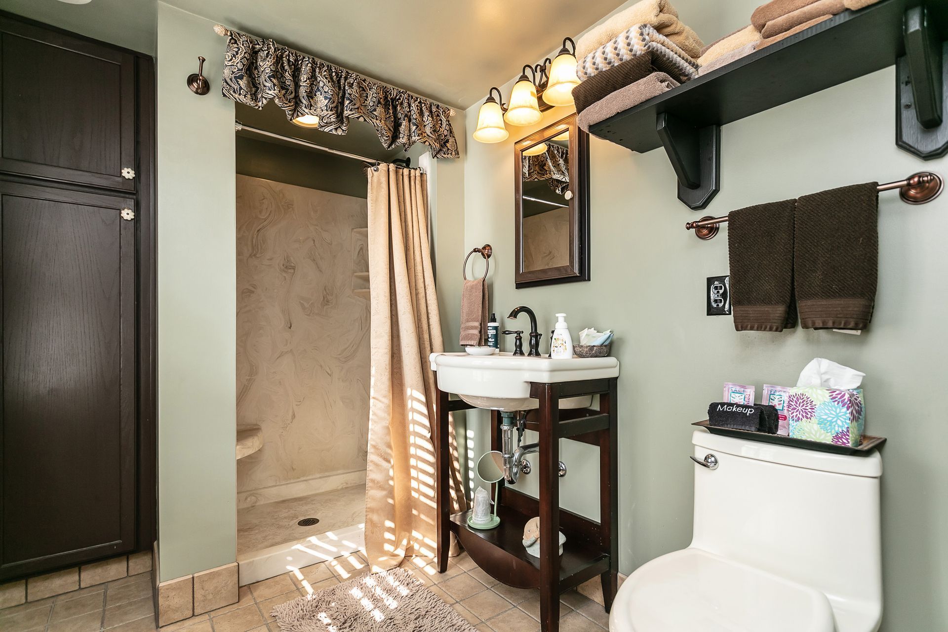 A bathroom with a toilet a sink and a shower