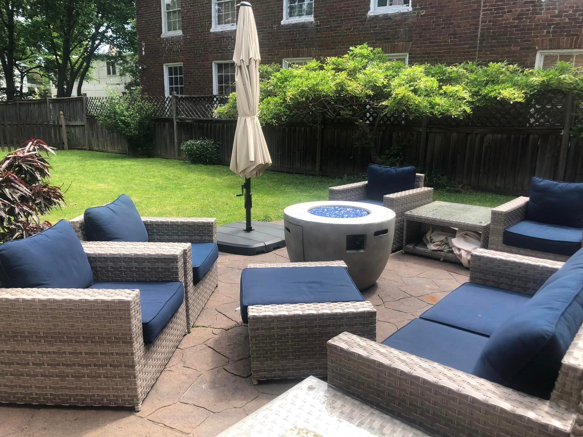 A patio with wicker furniture and a fire pit in the backyard