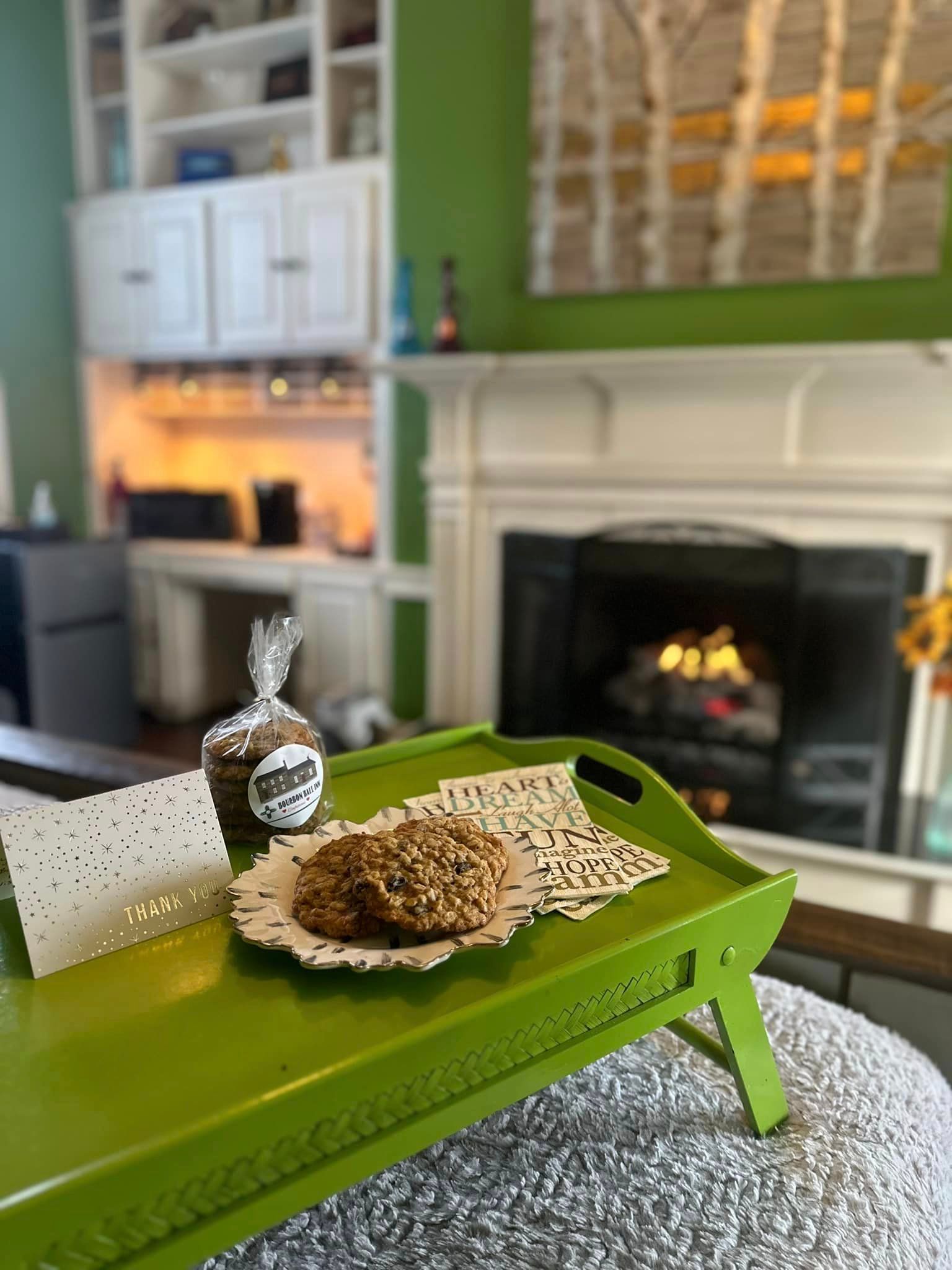A green tray with a cup of coffee and cookies on it in a living room.