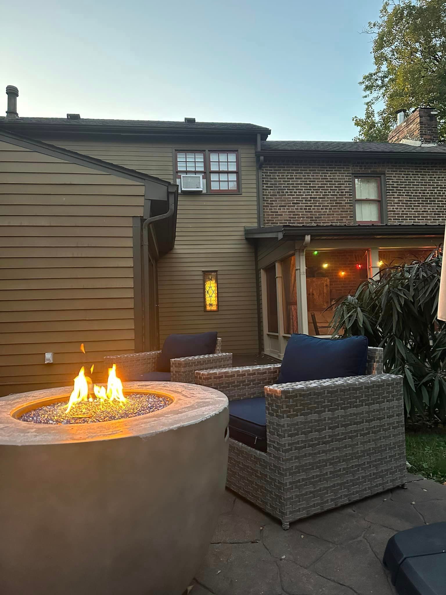 There is a fire pit in the backyard of a house.