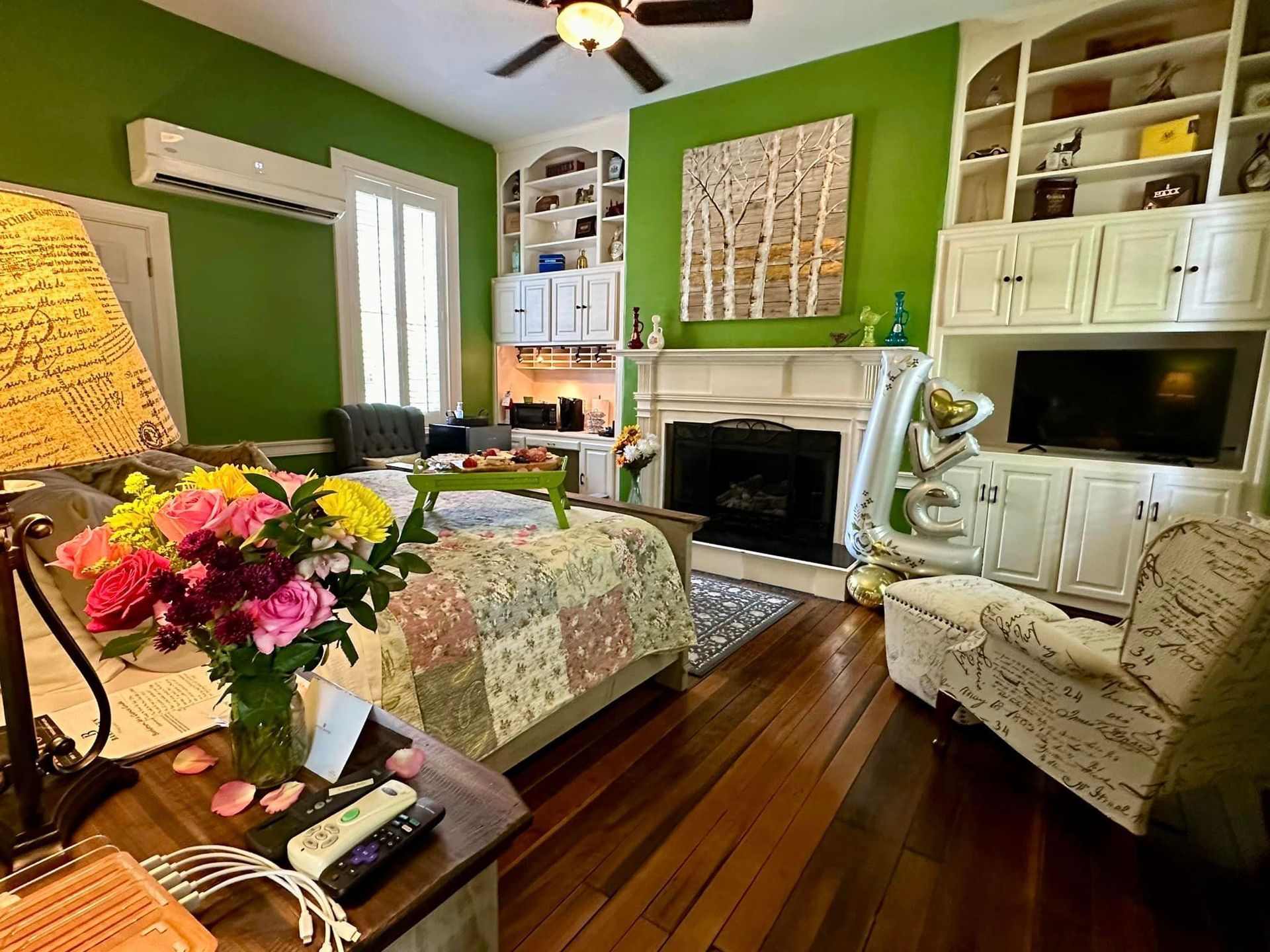 A living room with green walls and a fireplace.